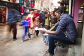 <b>NPL1002</b><br>Nepal; Kathmandu; Siddhidas Marg; Street; People; Bazaar; Newspaper; Reading; Walking; Morning; Shop; Seller